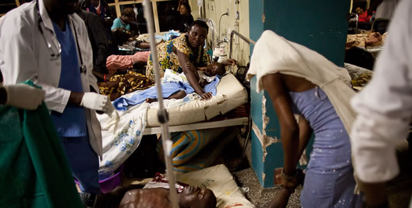 Doctors treat victims at Mulago hospital in Kampala in Kampala late on July 11, 2010 after twin bomb blasts tore through crowds of football fans watching the World Cup final, killing 64 people, including an American, and wounding scores others.