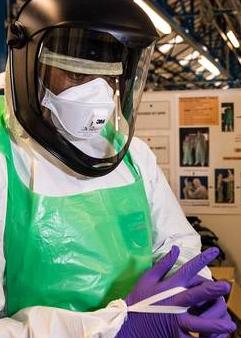 The UK military medical team trying on the new protective gear that includes a visor instead of goggles. The suit material is much lighter to ease the discomfort of working in a humid and high temperature environment.