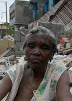 A woman sits amid the rubble of the quake