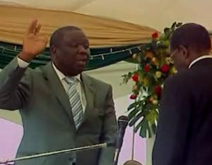 PM Morgan Tsvangirai takes the oath before arch rival Mugabe